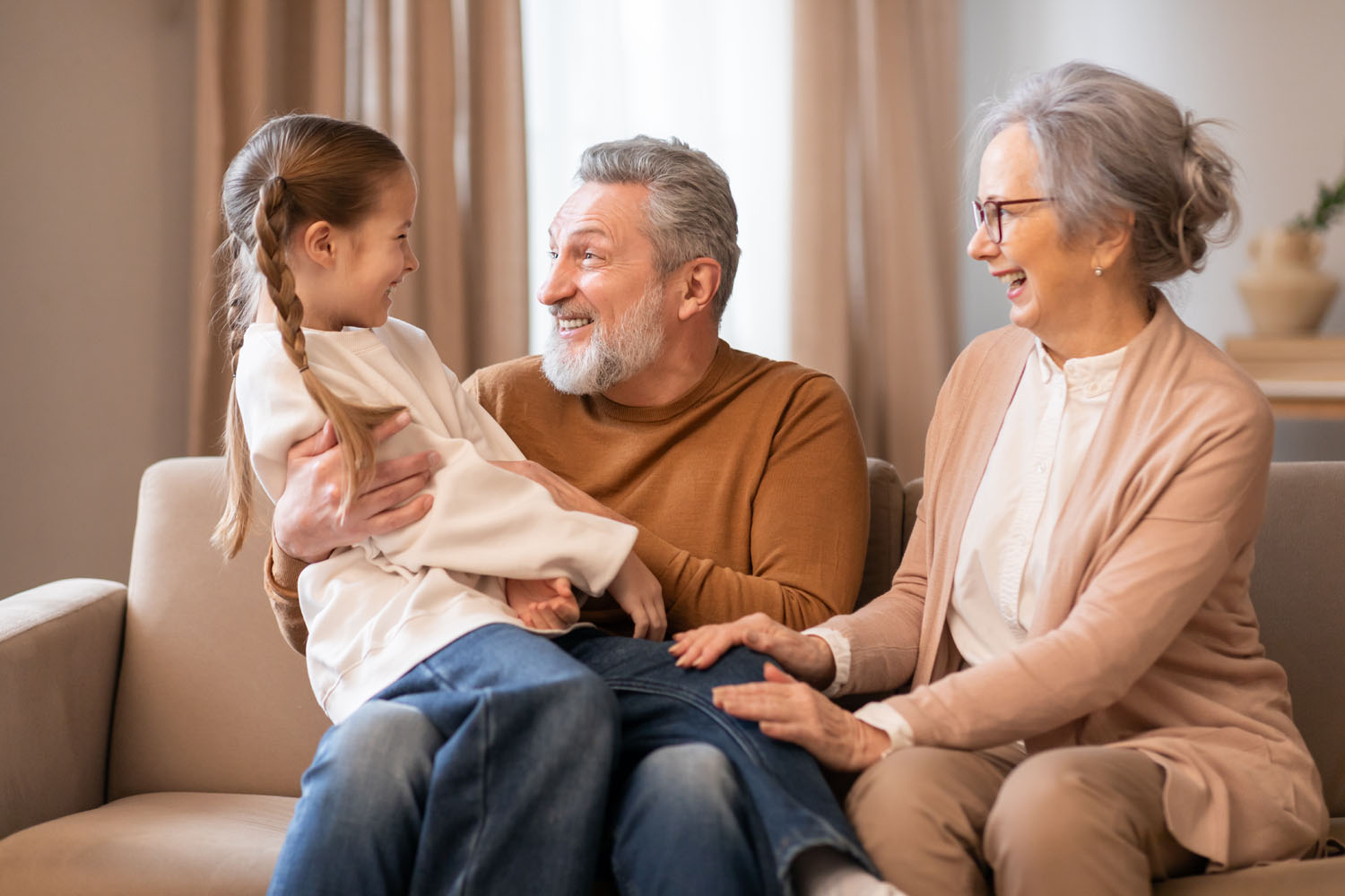 Grandparents on a couch with their granddaughter